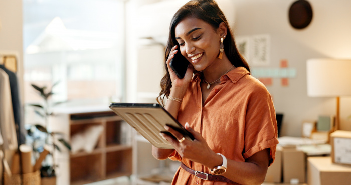 An African-American woman talking on the phone while holding an iPad